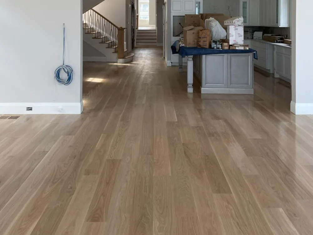 Installation of high-quality hardwood flooring in a modern home with an open layout.