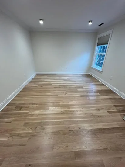 White oak flooring installation in a room with side window and lights