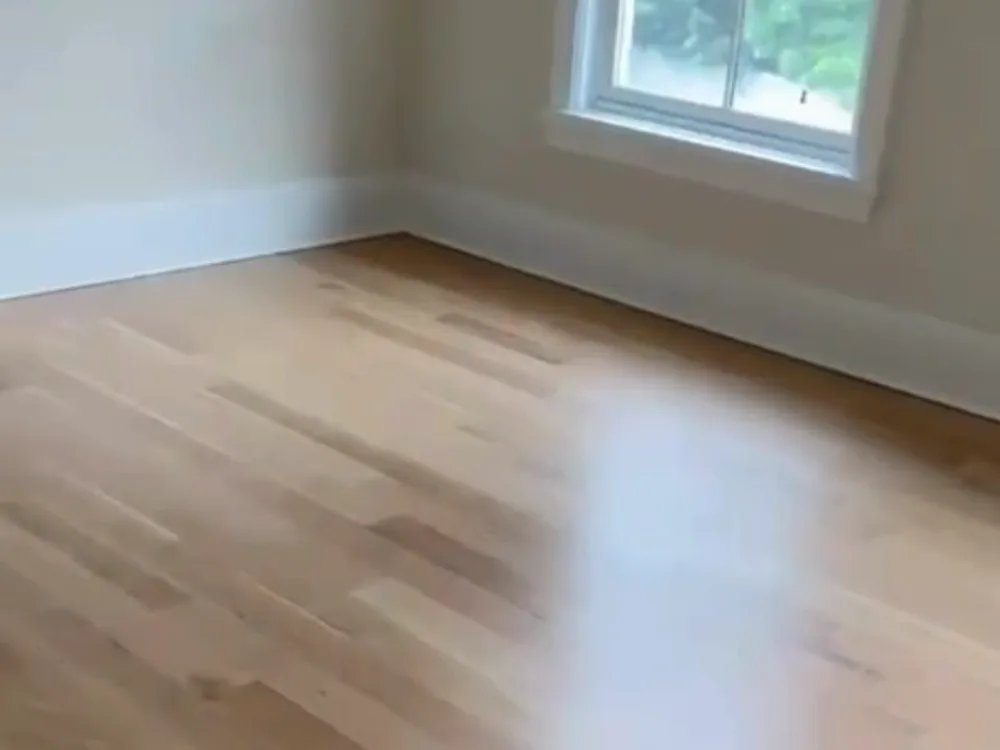 hardwood floor installation in bright corner with natural light.