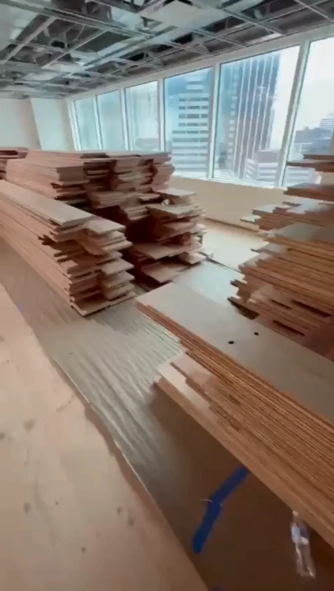 Stacked long wooden planks for ongoing wood flooring installation