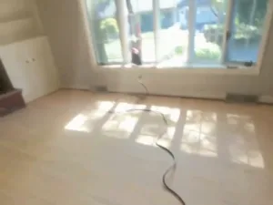 hardwood floor refinishing during surface preparation in living room area
