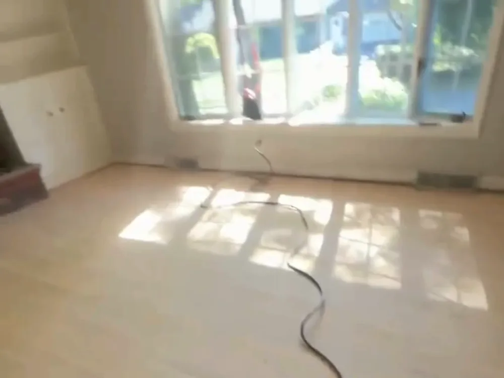 hardwood floor refinishing during surface preparation in living room area