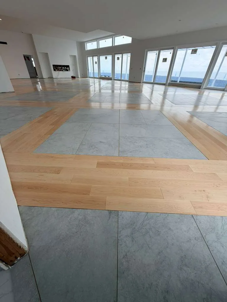 4-inch prefinished custom maple inlay surrounding large gray floor tiles in a bright room.