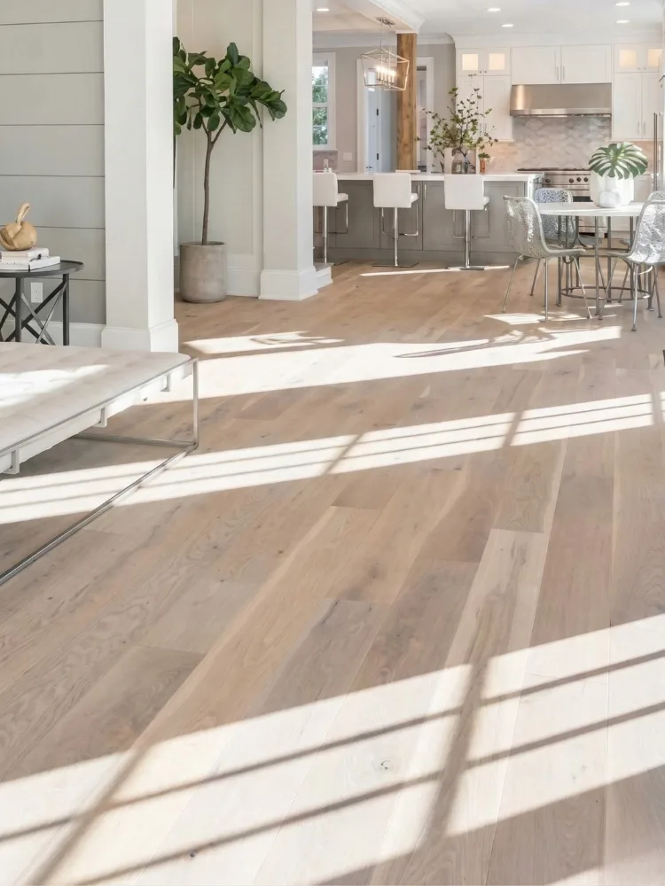 Hardwood floor installation connecting an open living area to a modern kitchen.