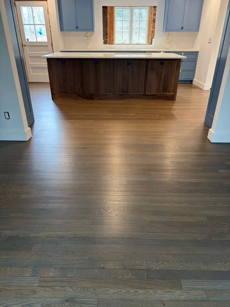 Close-up of the kitchen floor grain highlighting the matte finish of the aged barrel floor stain.