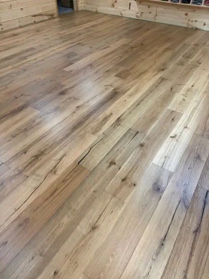 Close-up detail of Vermont rustic cabin flooring showing the natural grain and texture of the installed hardwood.