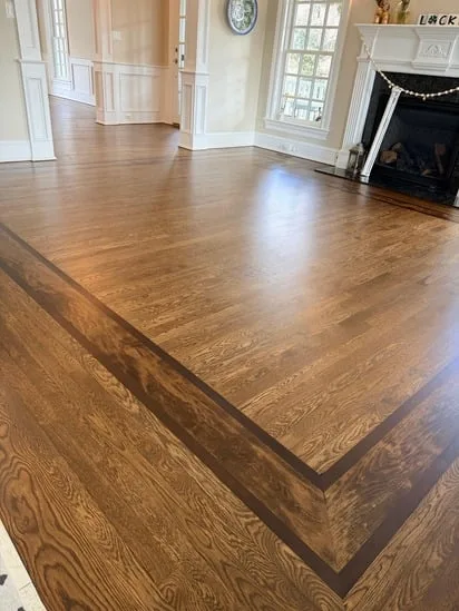 Decorative dark border inlays highlighted by Dark Walnut Floor Refinishing.