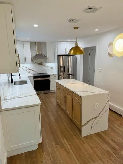 Modern kitchen island with a quartz waterfall countertop completed during a weathered oak kitchen renovation.